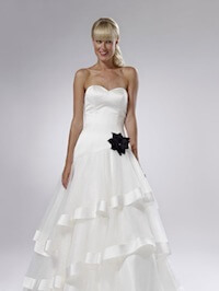 white wedding dress with a black flower on the left hip