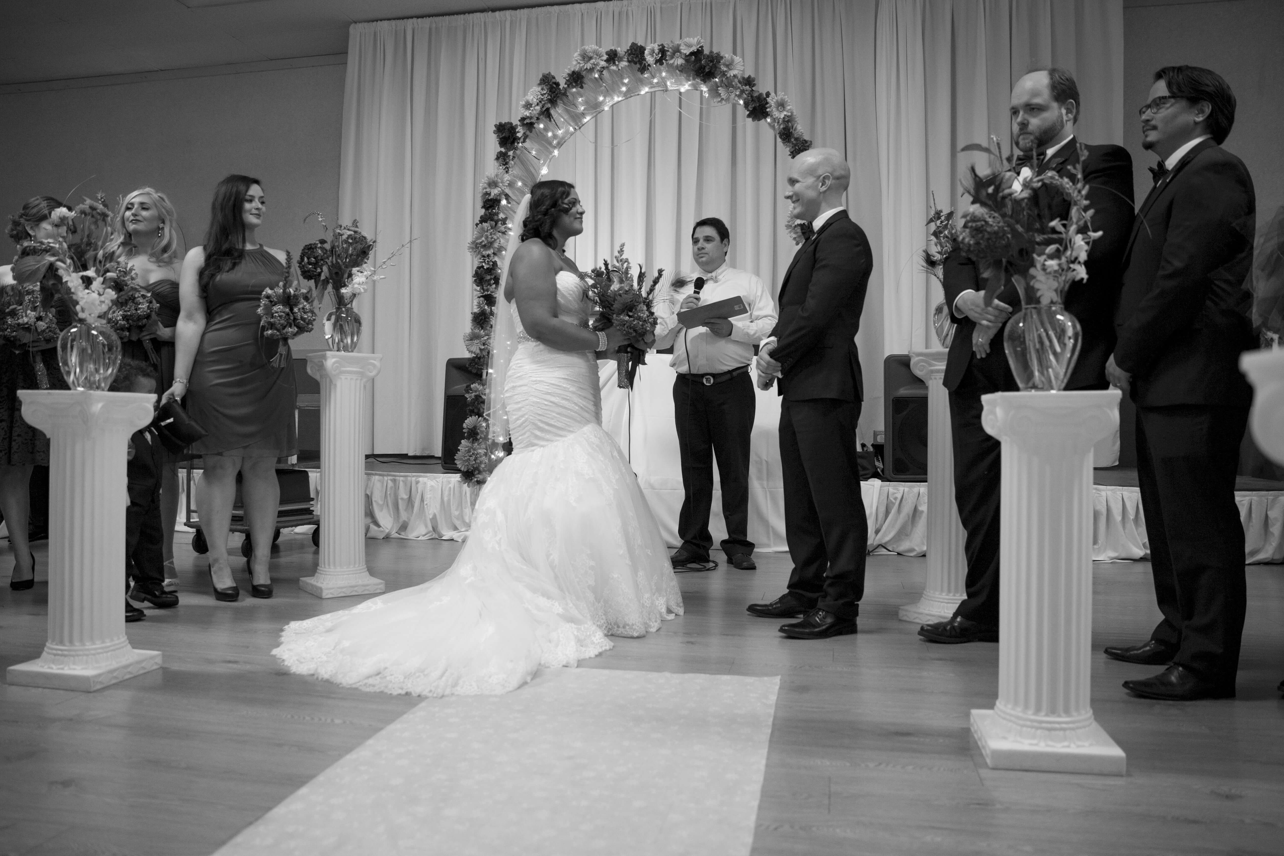 black and white photo of the bride and groom at the aisle with their wedding party