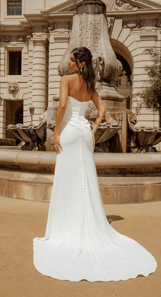 back of sleeveless, elegant wedding dress, Collins, with a high thigh slit and long train