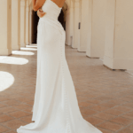 Back of sleeveless, elegant wedding dress, Collins, with a high thigh slit and long train