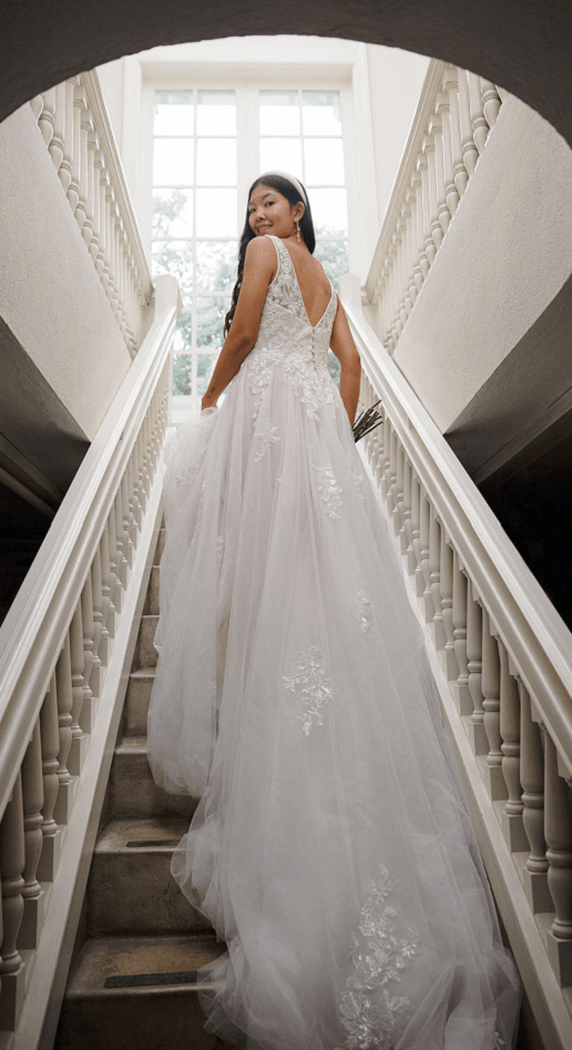 Bride going up the stairs looking back, wearing a beautiful lace and chiffon wedding dress, Maryam