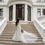 Beautiful bride wearing a lace and chiffon wedding dress, Maryam, on big stairs